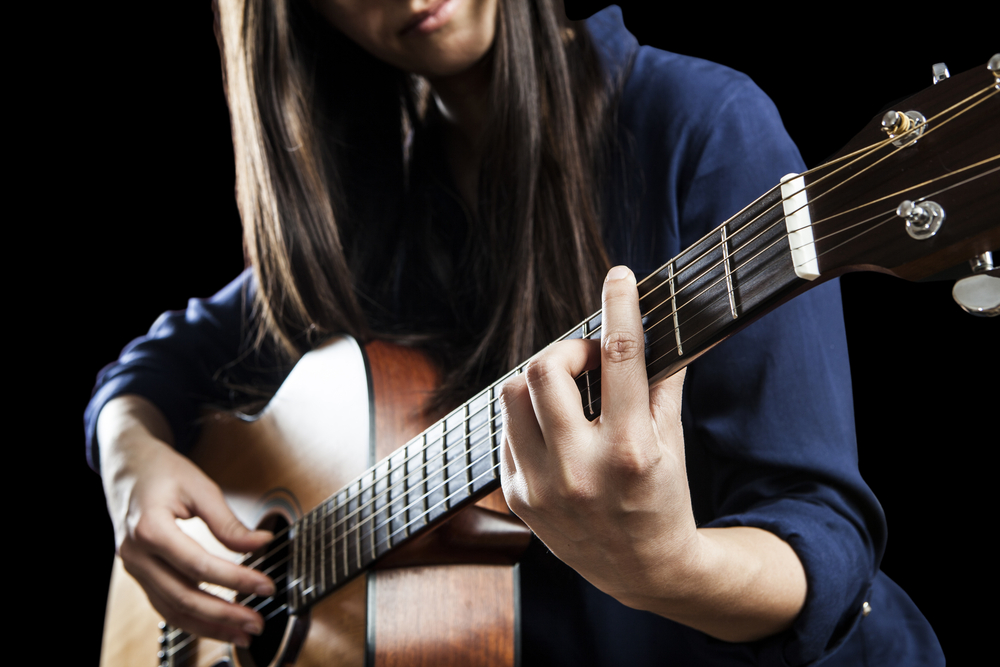 Female Singer Playing An Acoustic Guitar
